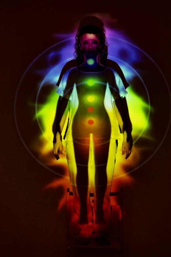 contact-bg Human silhouette with vibrant chakra energy projection, symbolizing balance and spirituality.